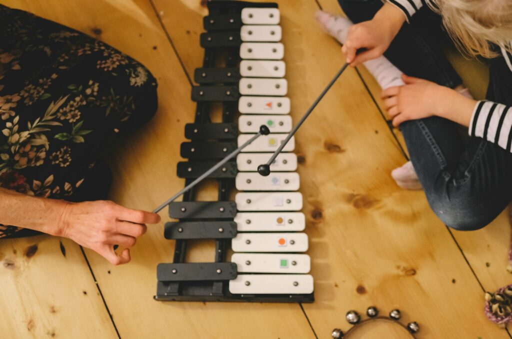 a man and a little girl playing a musical instrument